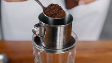 a person pouring a coffee into a glass cup