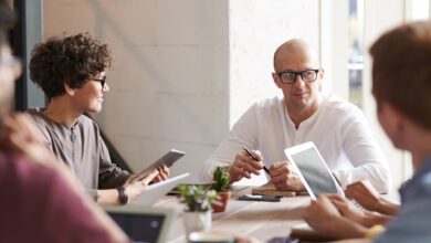 Entrepreneurs collaborating in a modern office meeting with tablets and laptops