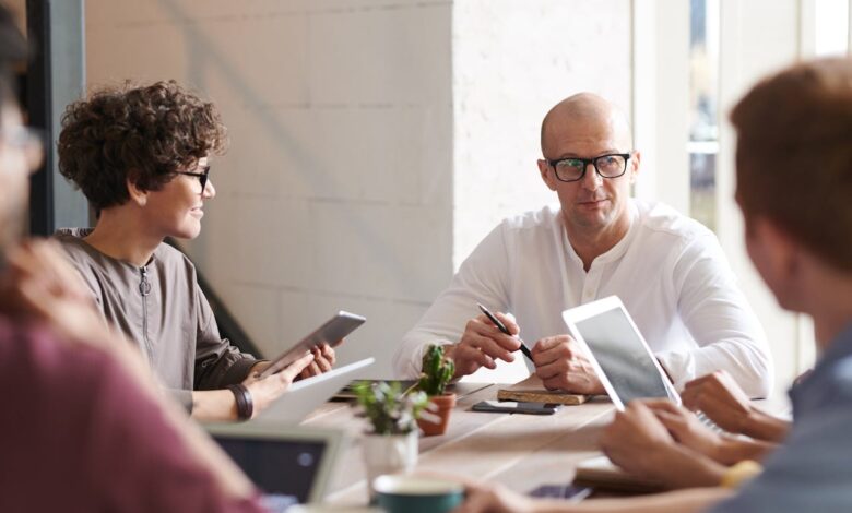 The Best Business Ideas to Start in 2025 1 Entrepreneurs collaborating in a modern office meeting with tablets and laptops