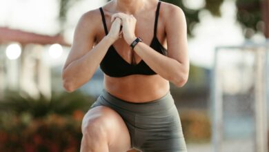 Afocused woman performing a squat exercise outdoors in sportswear – symbolizing Olympic-style training discipline and strength.